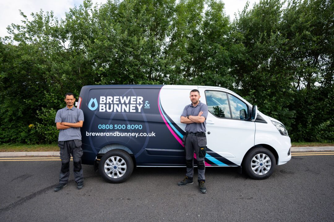 Two engineers stood in front of a van.