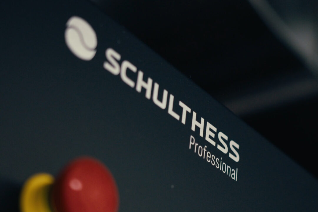 A close up of a Schulthess badge on a stacked commercial laundry machine